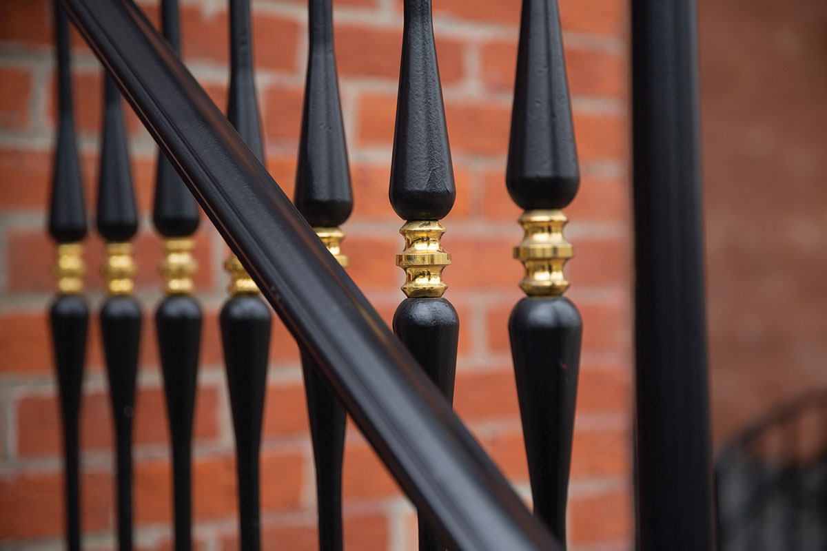 Exterior railing, powder coated steel posts with bronze centers outside a school