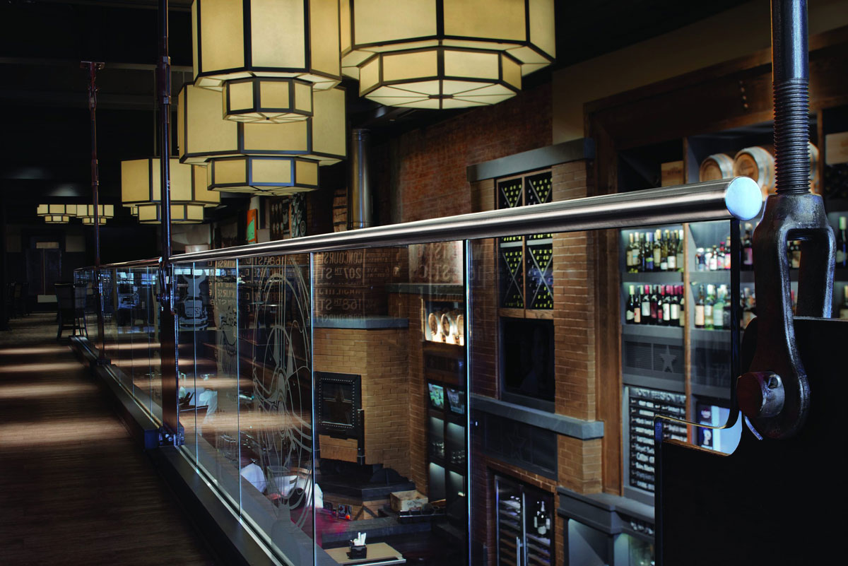 Stainless steel glass railing with fittings inside a restaurant