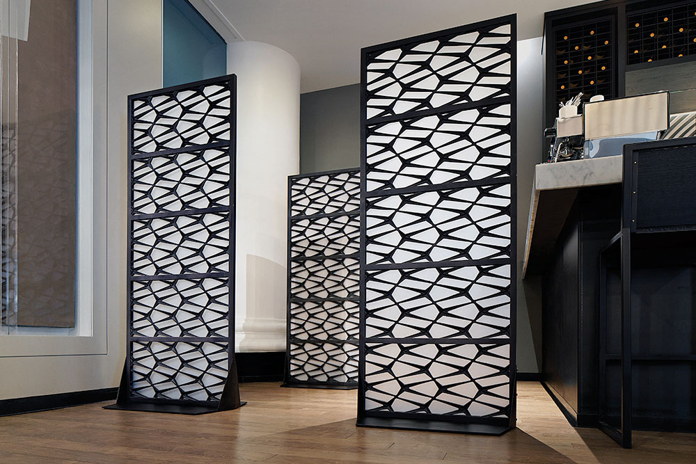 Steel treillage panels used as screens inside a restaurant